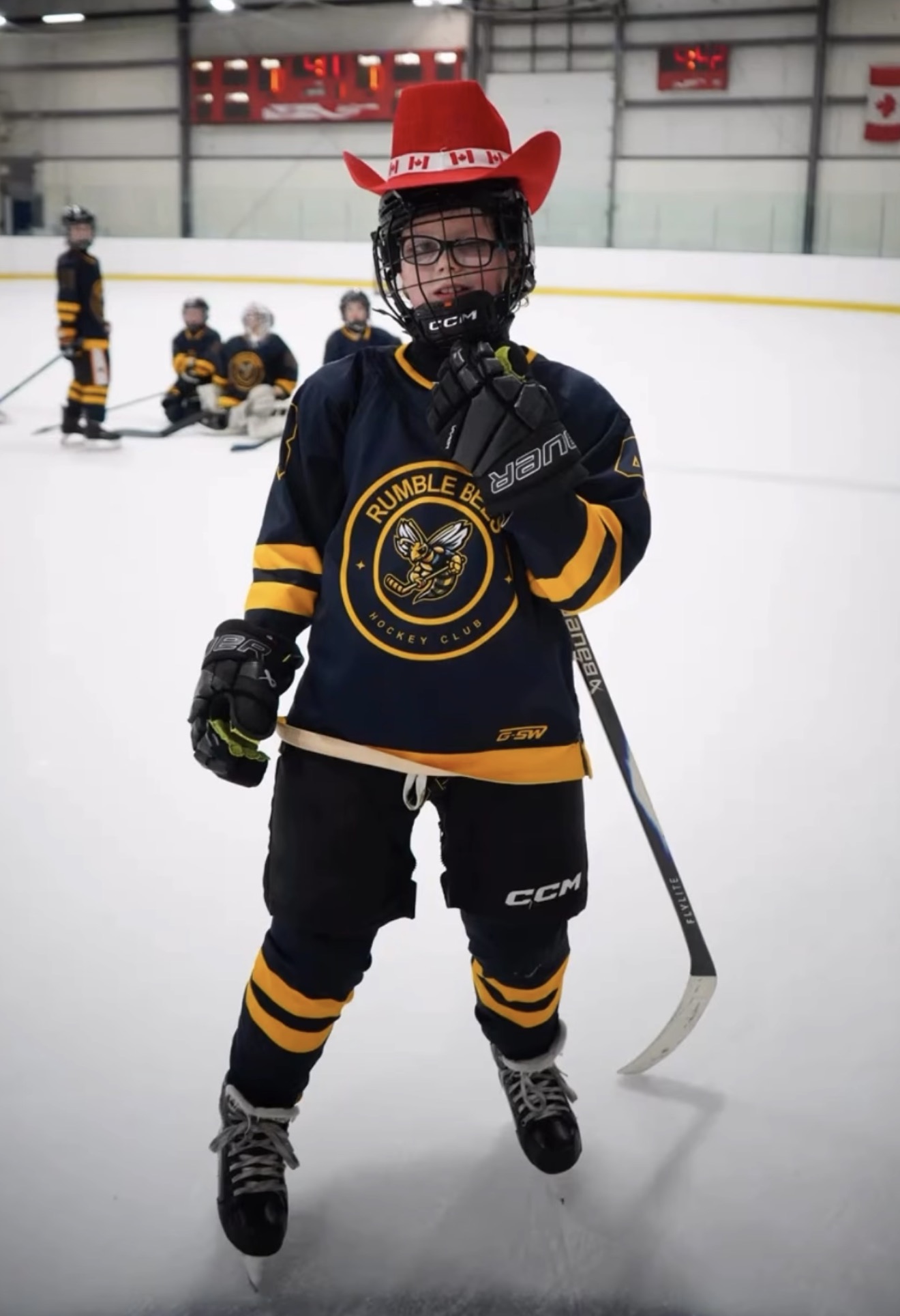 Young player in a Canada cowboy hat on the ice